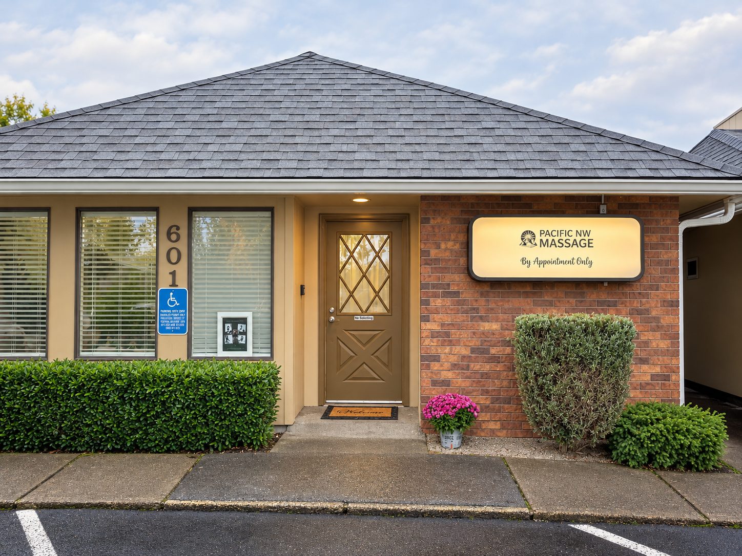 Front of the studio at Suite 601 with the lit Pacific NW Massage sign beside the door